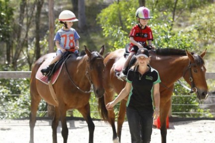 a couple of people riding on the back of a brown horse